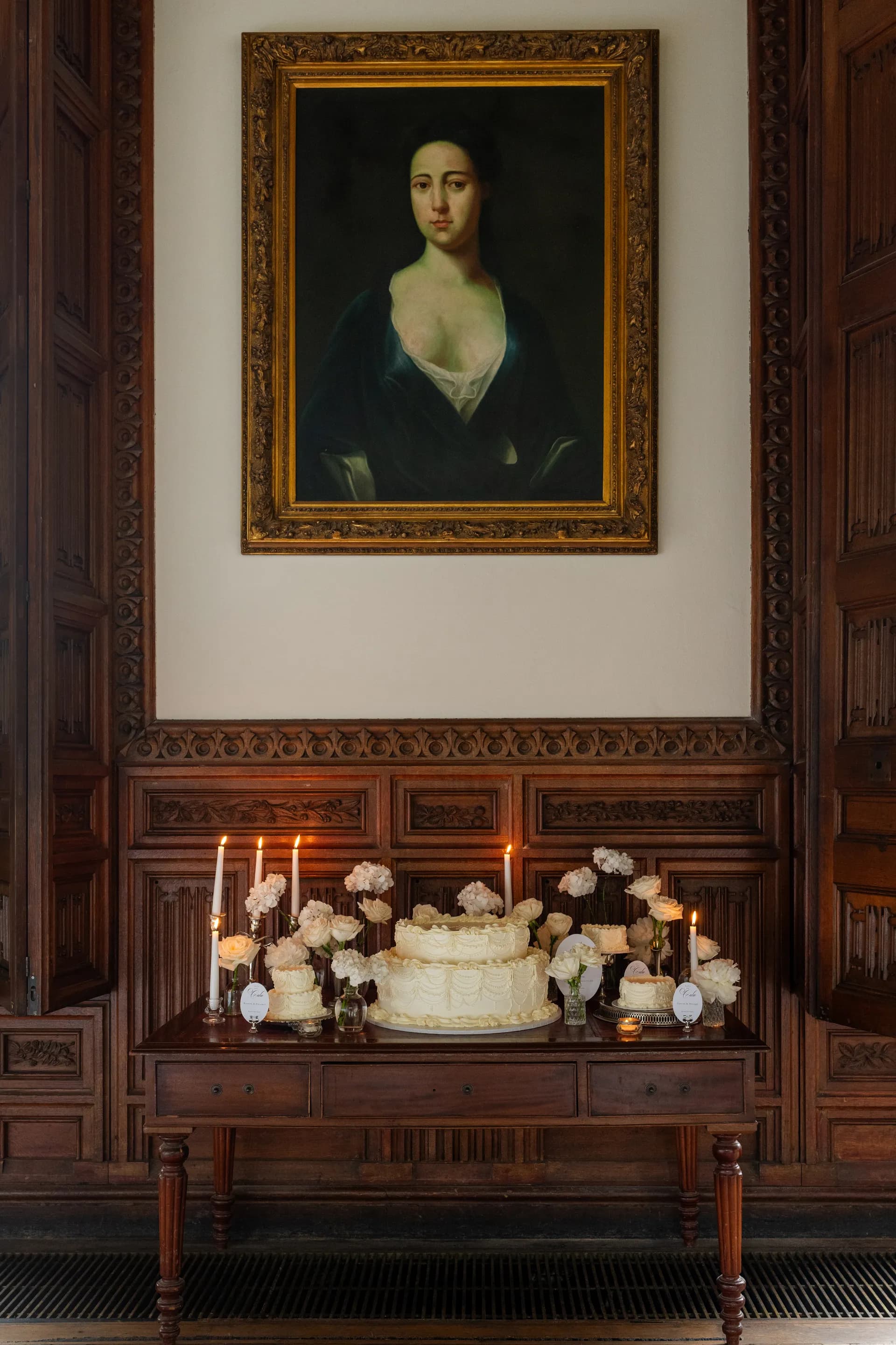 Wedding cake and candles in the panelled Lounge beneath a portrait