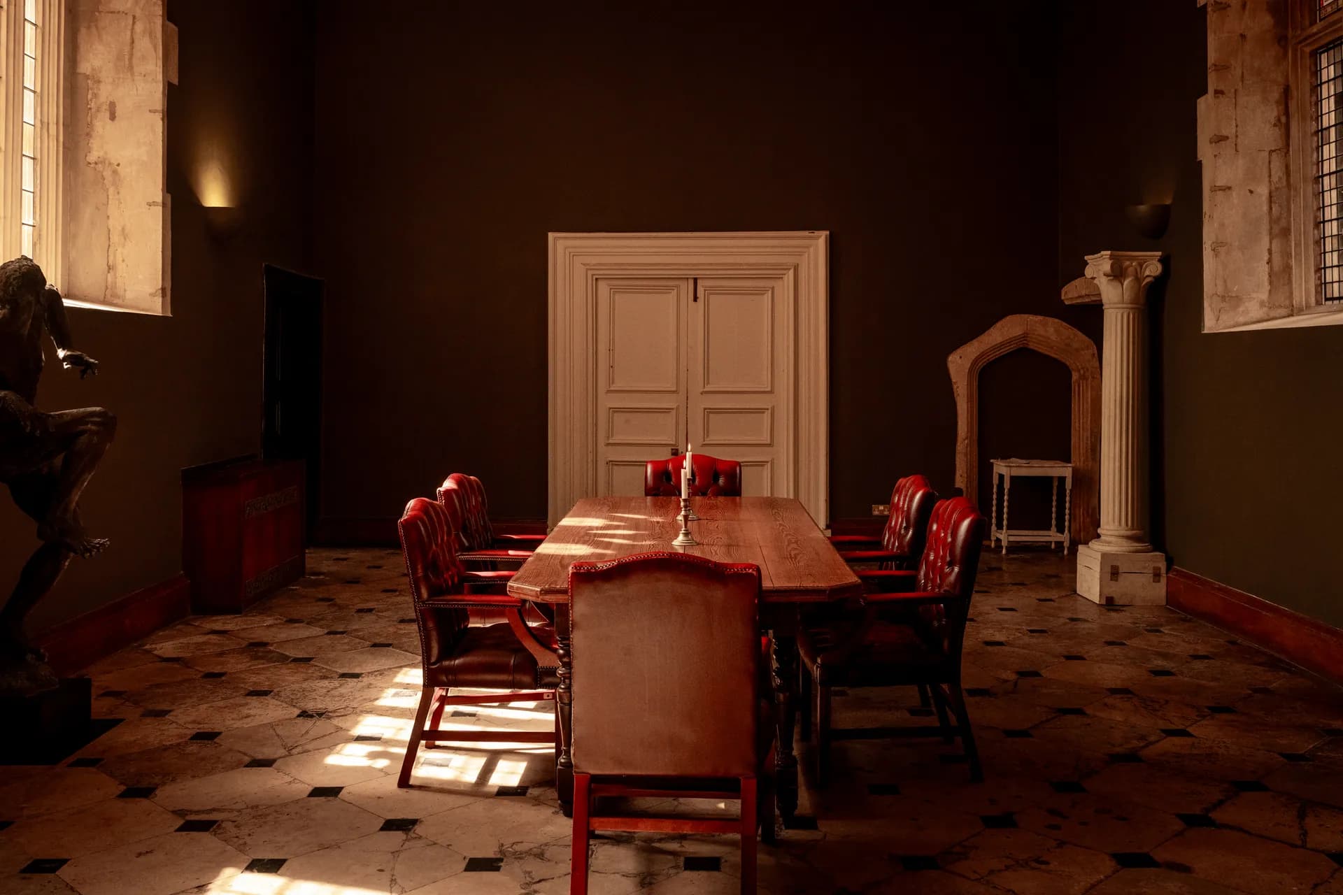 The dining room set for a meeting, long table and red chairs