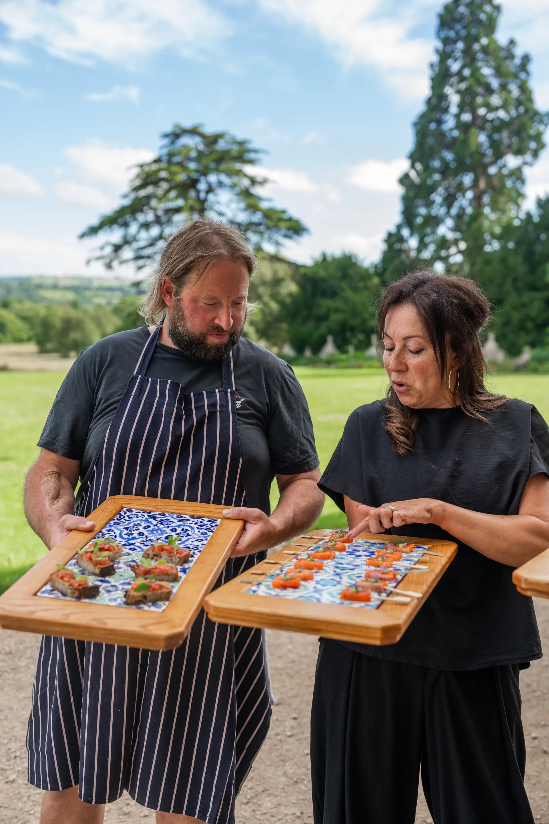 Two chefs presenting canapés on the lawn