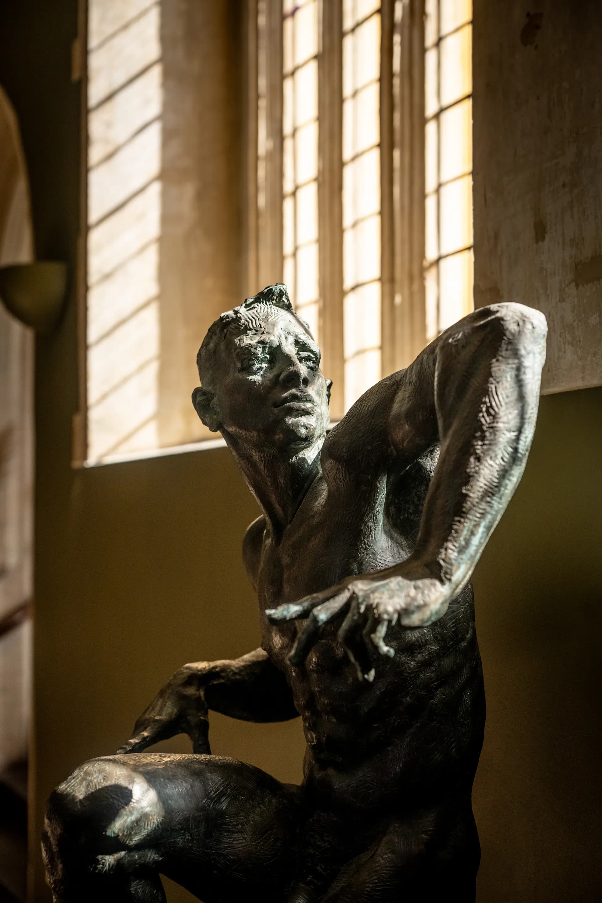 Bronze sculpture by a window